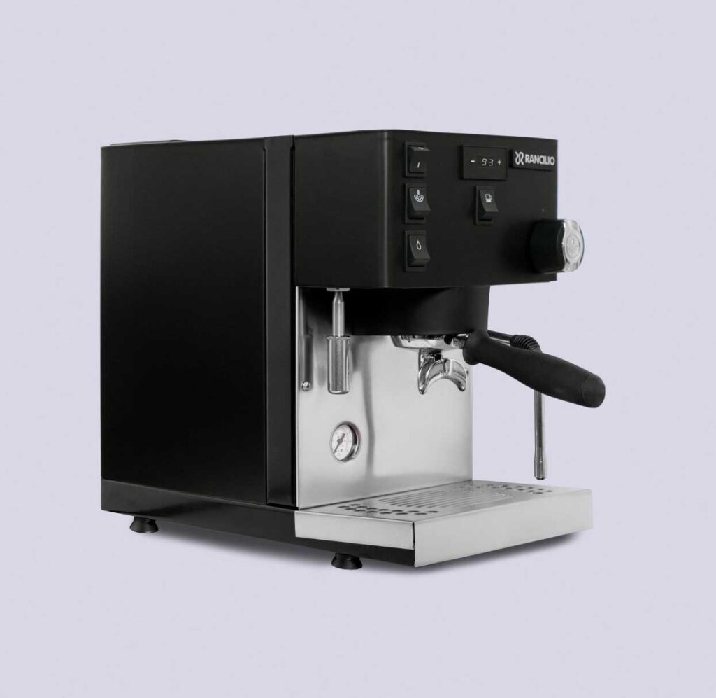 La máquina de espresso doméstica en negro, vista de lado, con el portafiltros y el vaporizador.