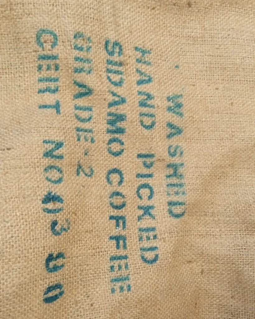 Saco de yute de café verde con el estarcido en verde «Washed, hand picked, Sidamo coffee, grade 2», el Sidamo lavado de Etiopía tal como llega al tostadero de Boconó, en abril de 2023