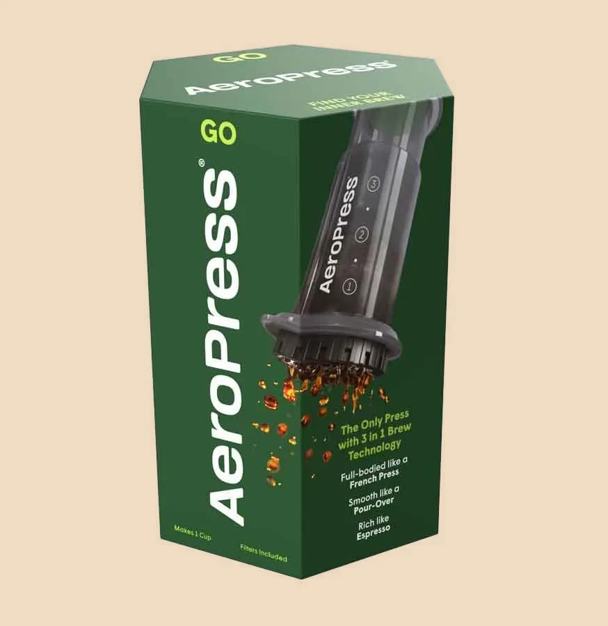 Caja verde de la cafetera de émbolo AeroPress Go con la fotografía del producto impresa.