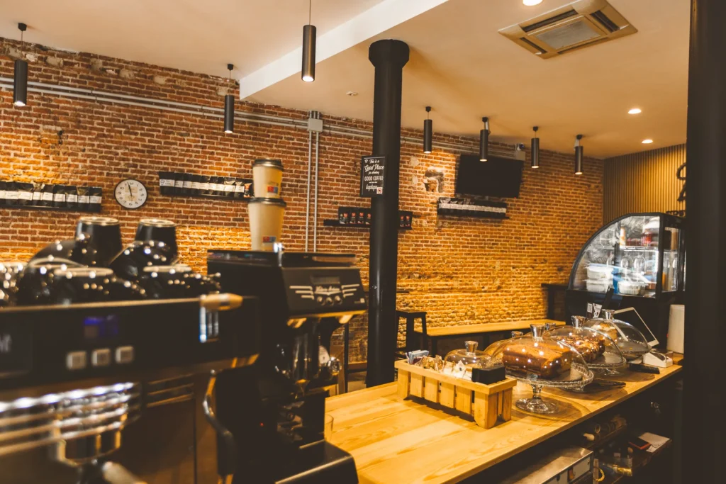 La barra de la cafetería de Boconó en Lavapiés, con los molinos de café, la máquina de espresso y la pared de ladrillo