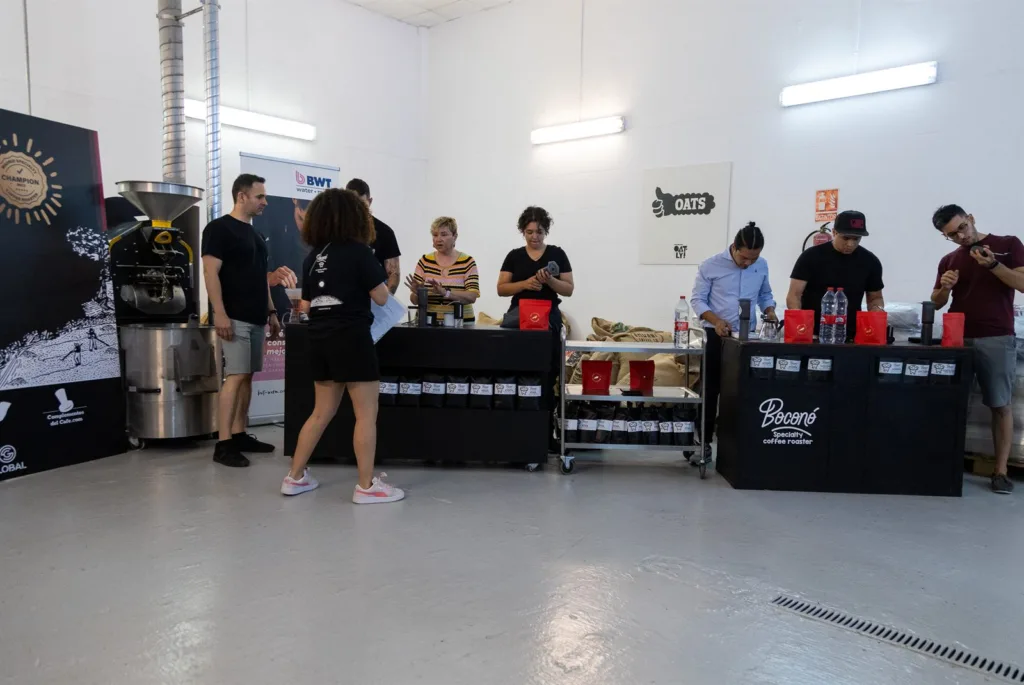 Vista general de la sala con el público en pie y las mesas de competición preparadas